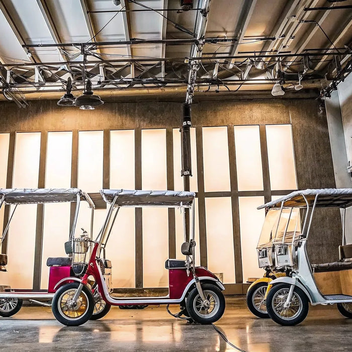 Four colorful e-trikes for sale displaying a variety of styles.