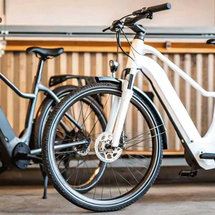 A black and a white electric commuter bike parked side by side.