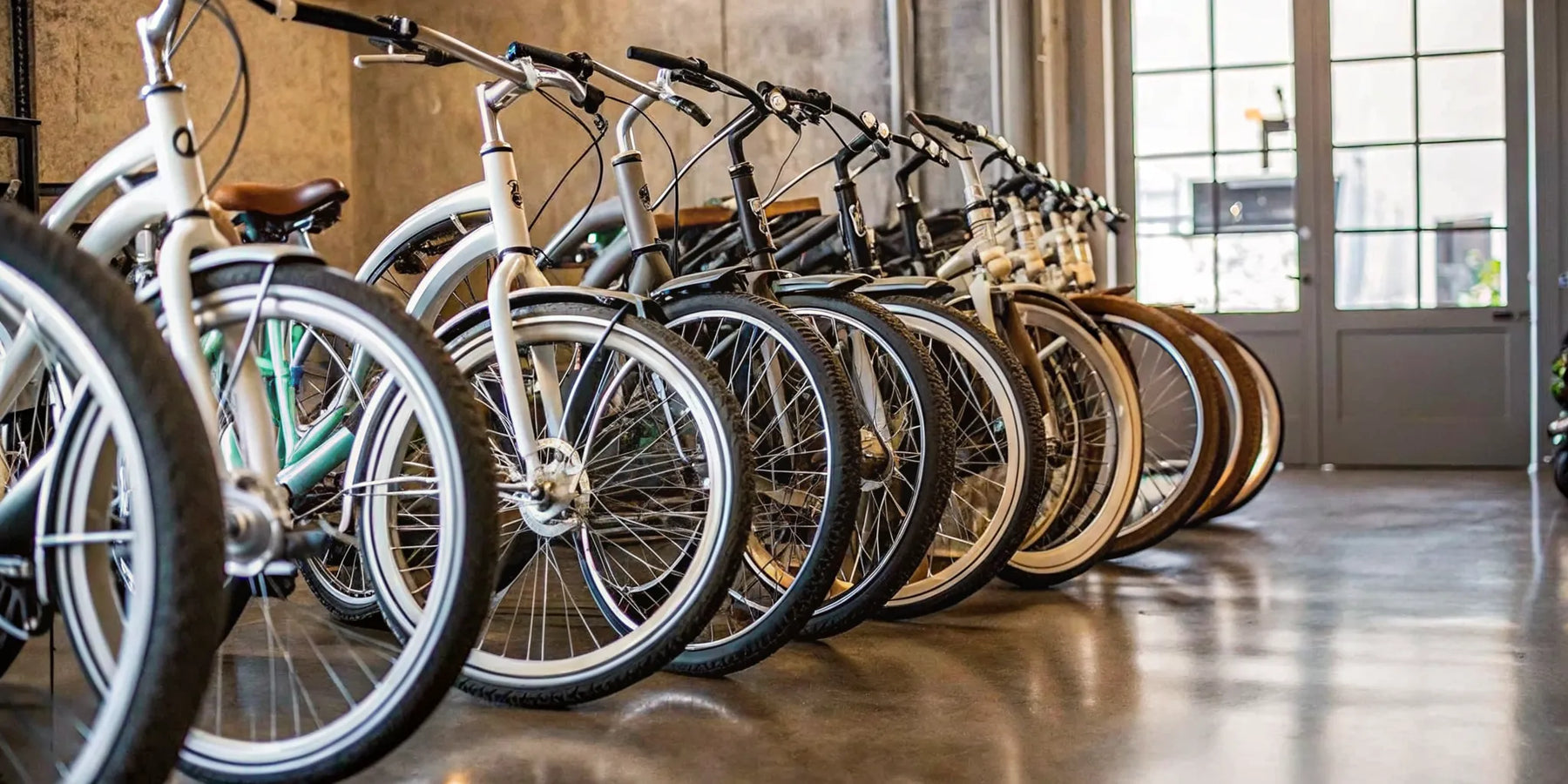 A lineup of cruiser ebike models with comfortable seats and wide tires in a bike shop.