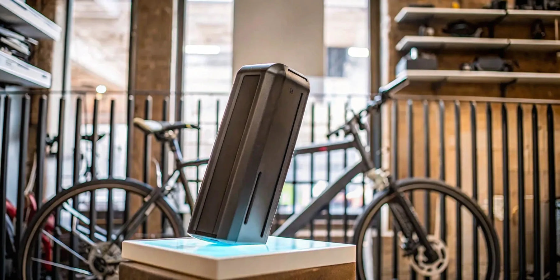 The cost of a replacement e-bike battery shown on a charging dock.