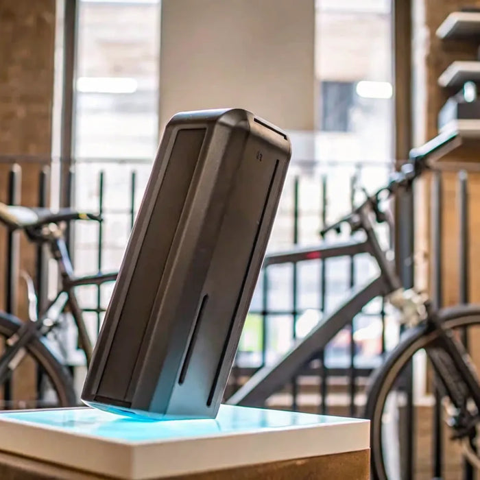 The cost of a replacement e-bike battery shown on a charging dock.