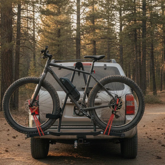 Fat tire electric bike secured to a vehicle rack outside a mountain trail