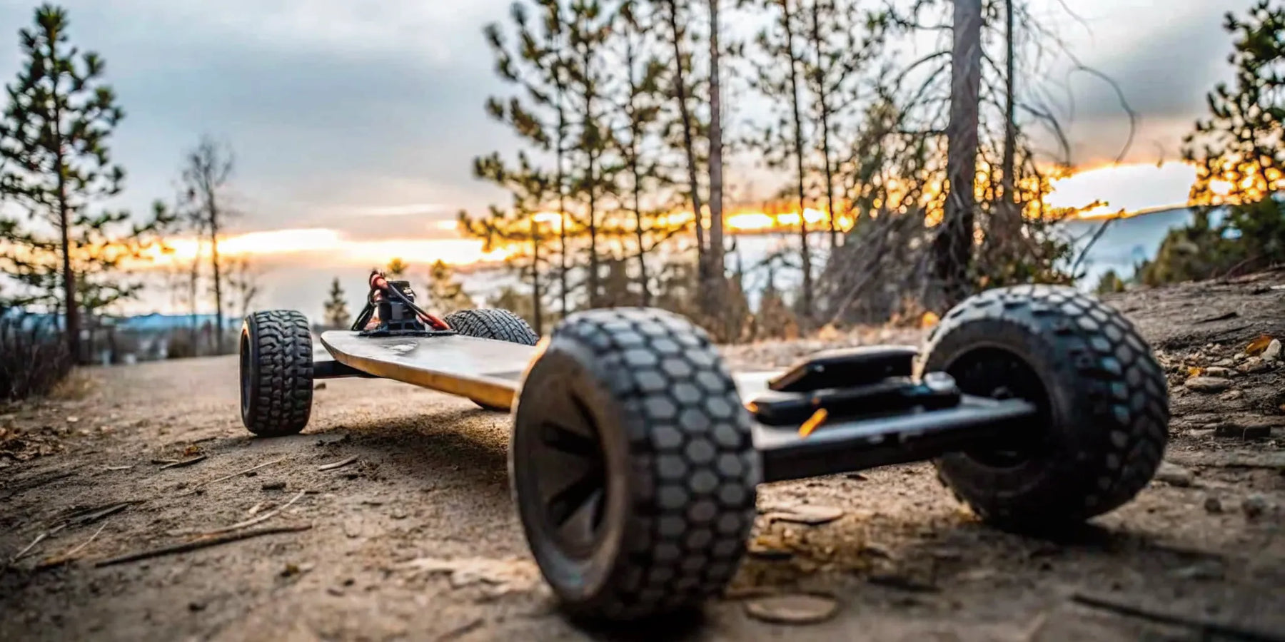 A high-performance off-road electric skateboard on a rugged trail in Bend Oregon during sunset