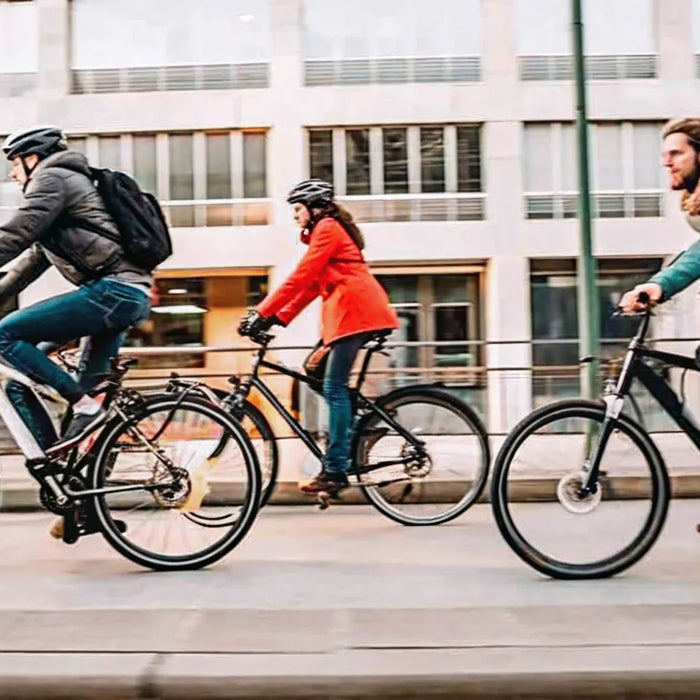 Three people on different e-bike models and classes comparing their top speeds in the city.