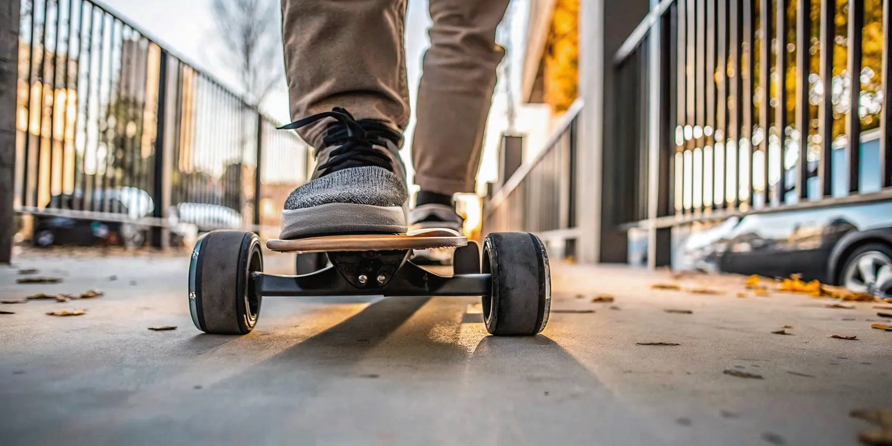A person riding a fast electric skateboard on a paved road.