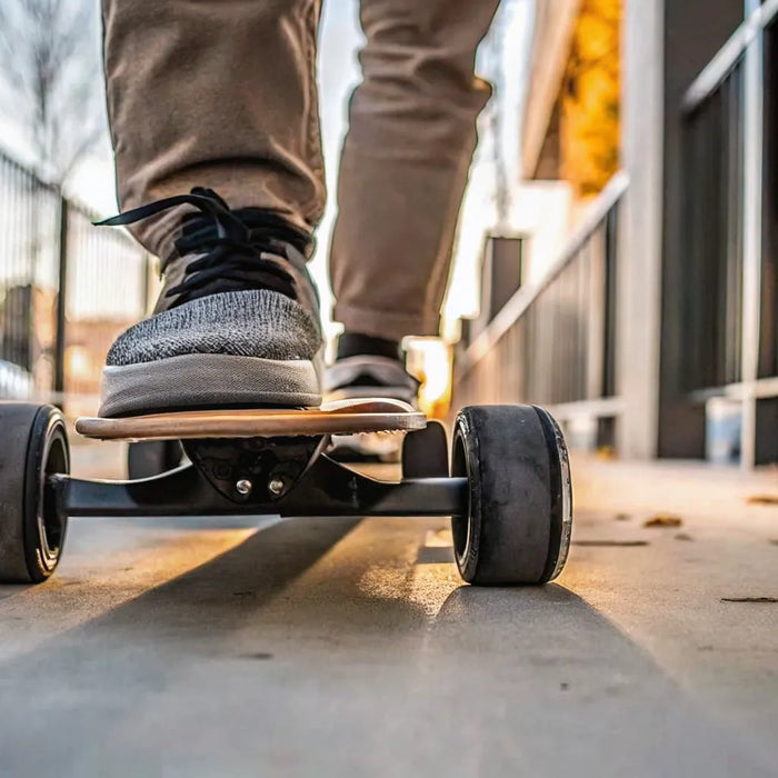 A person riding a fast electric skateboard on a paved road.