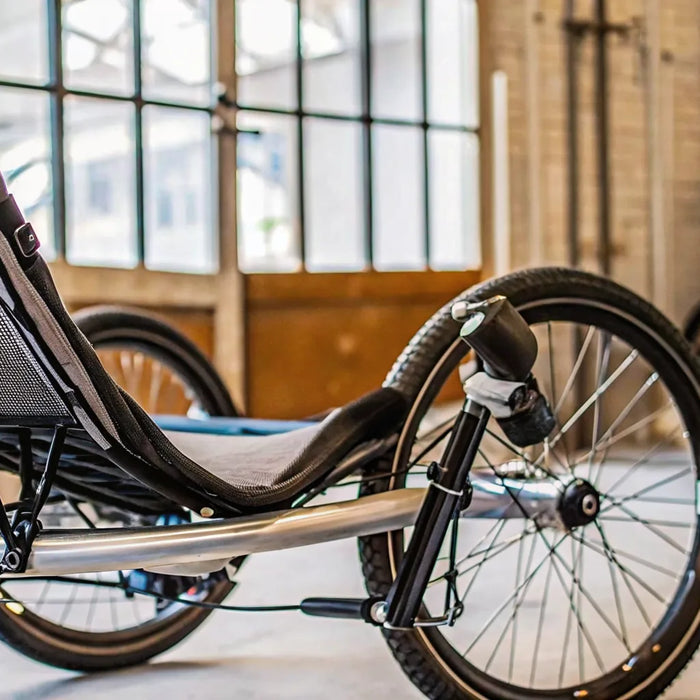 Recumbent electric trike with a mesh seat.