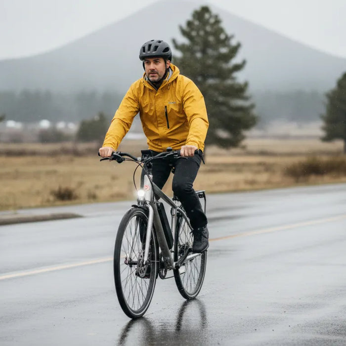 Adult rider on an electric bike in rain on a wet Bend road