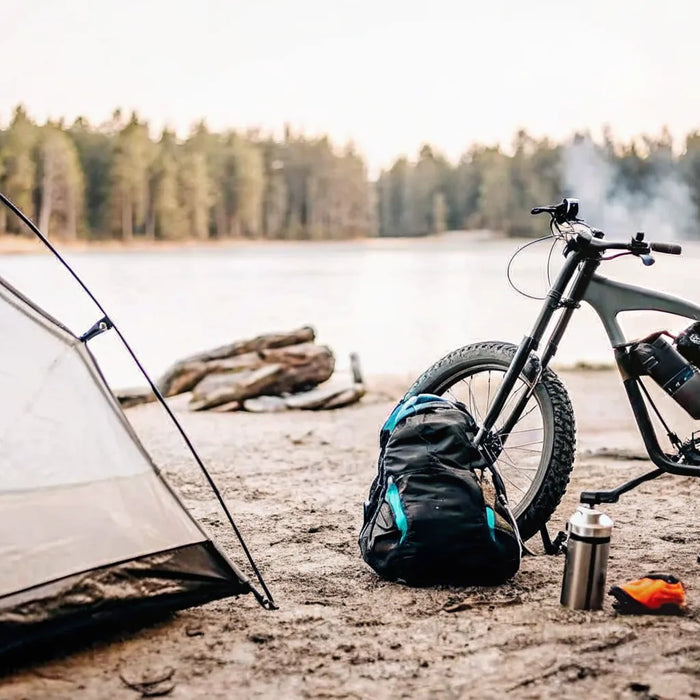 Segway Xaber 300 electric dirt bike for camping, parked at a lakeside site.