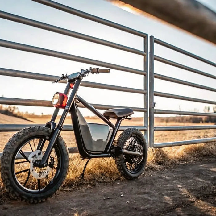 Segway Xaber 300 electric dirt bike on a dirt path by a ranch gate.