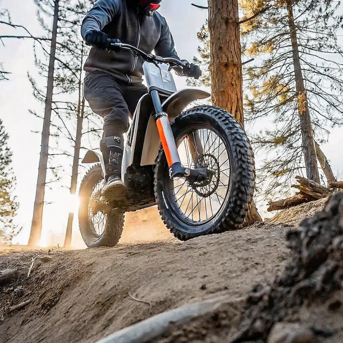 Segway Xaber 300 electric dirt bike riding on a single track through the forest.