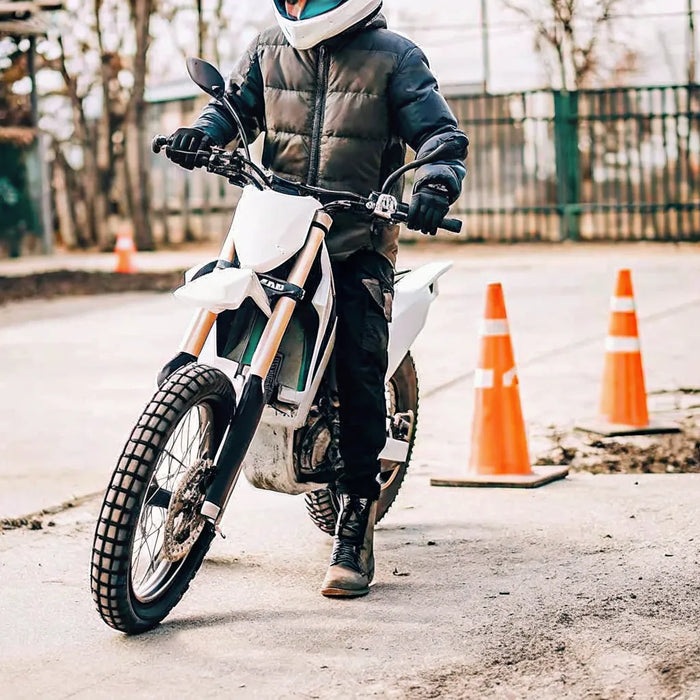 A beginner rides the Segway Xaber 300 electric dirt bike on a training course.