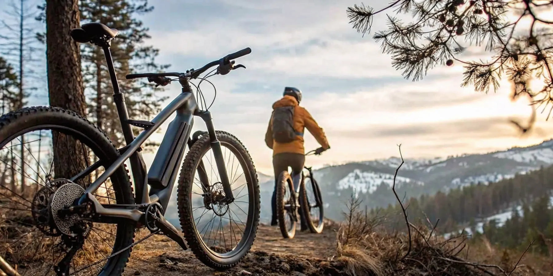 Best off-road electric bike for adults on a mountain trail at sunset with snowy hills.
