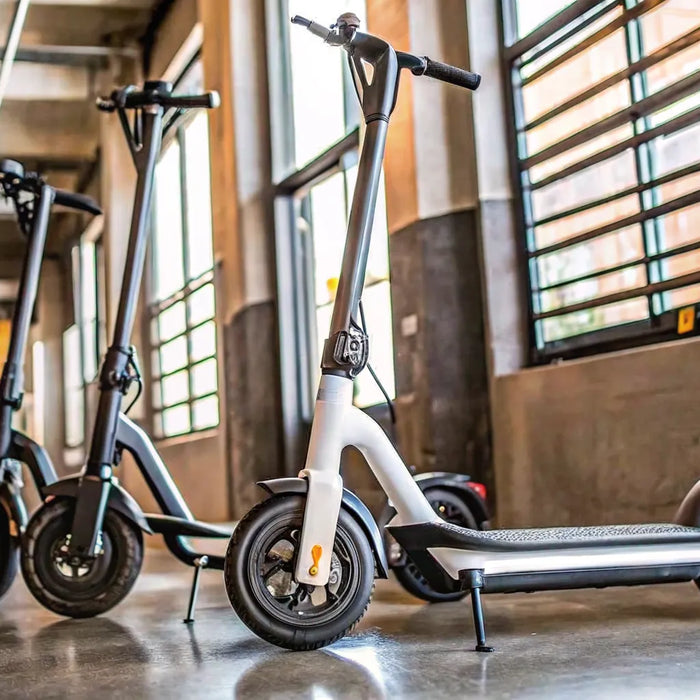 A modern seated scooter for adults with a comfortable seat, parked indoors.