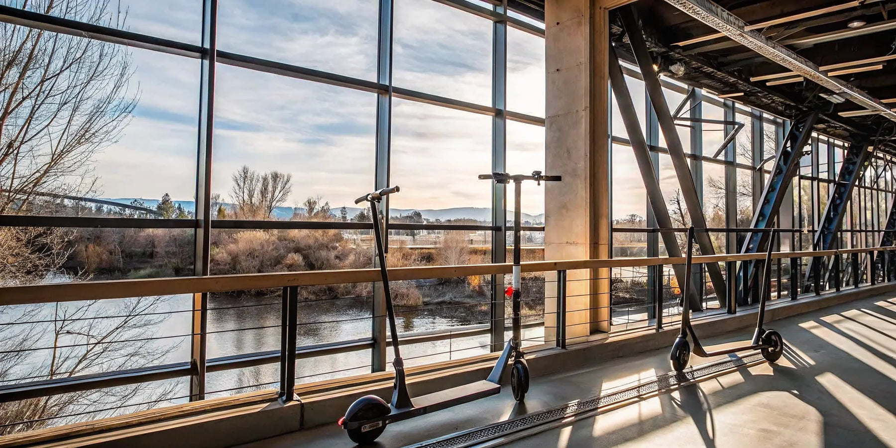 A pair of electric scooters to buy in Bend, Oregon, parked with a scenic river view.