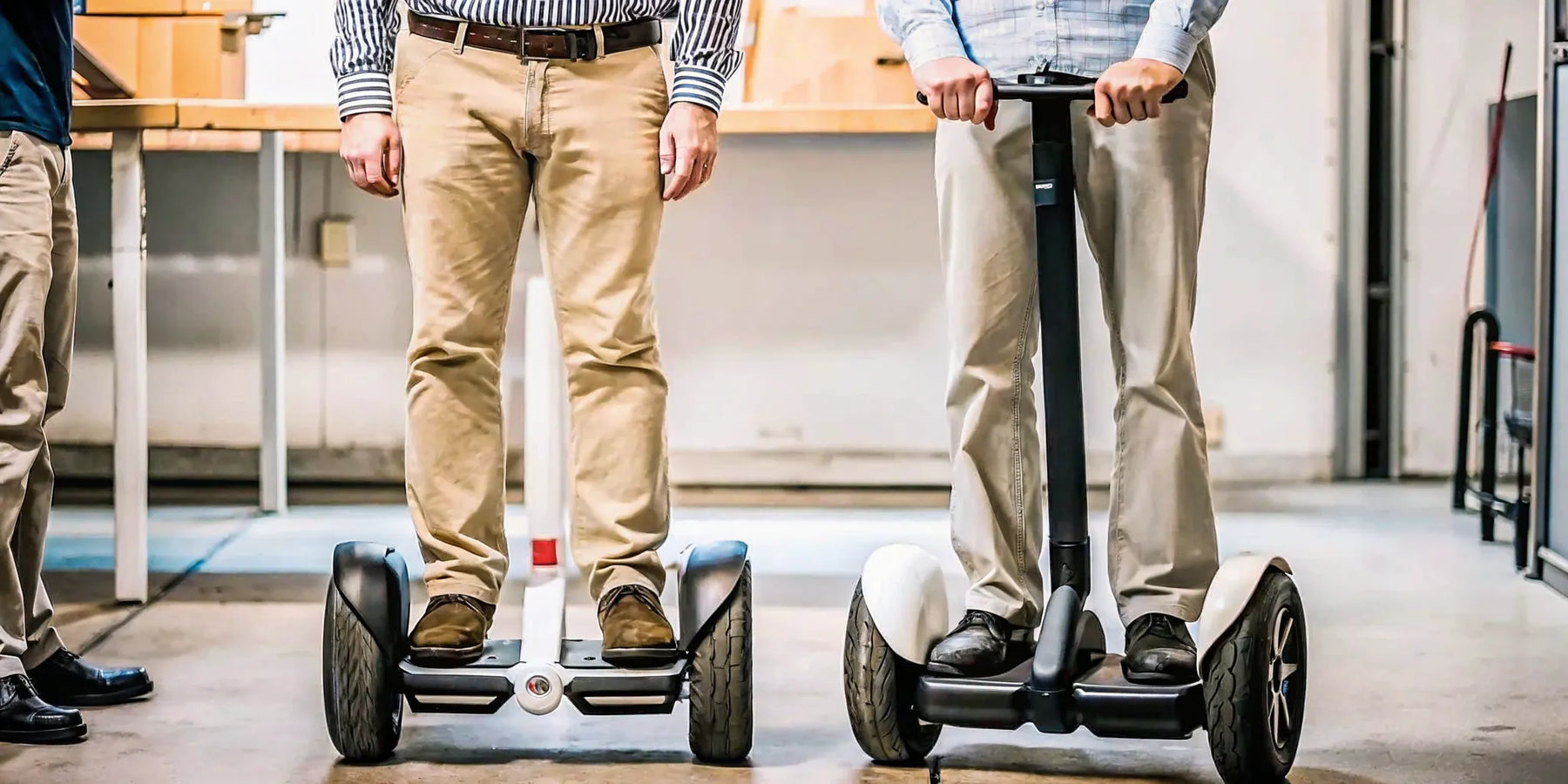 Two people riding classic two-wheeled Segway personal transporters.
