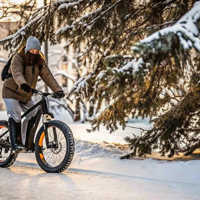 Rider on a fat-tire e-bike pedaling through fresh snow on a quiet Central Oregon street in winter