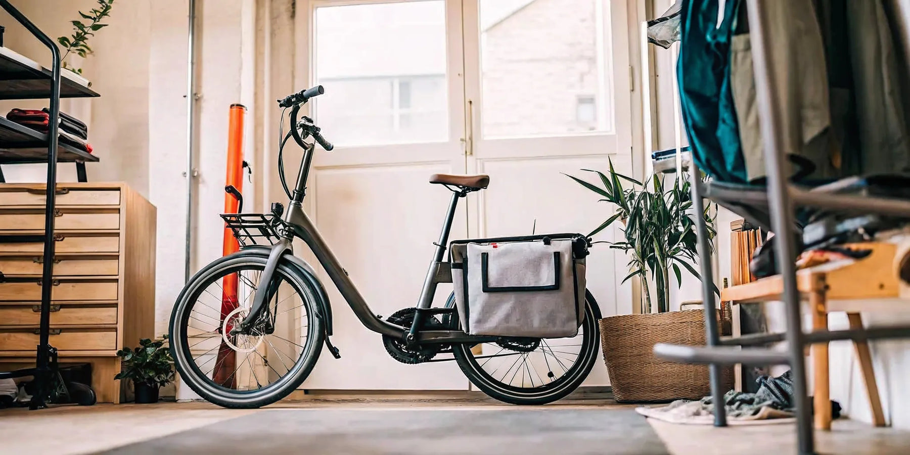 A folding electric cargo bike for adults, folded indoors to demonstrate its compact storage.